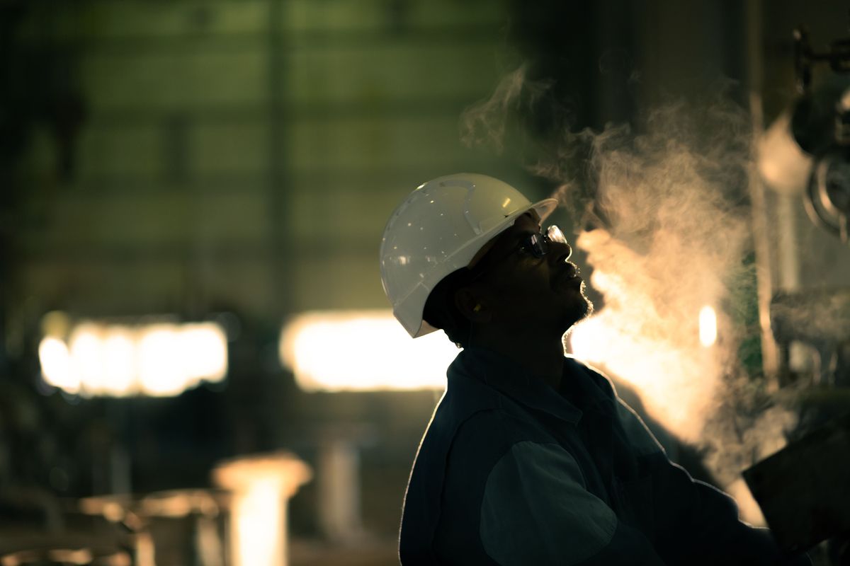 Inspector in a hard hat and safety glasses at an industrial site