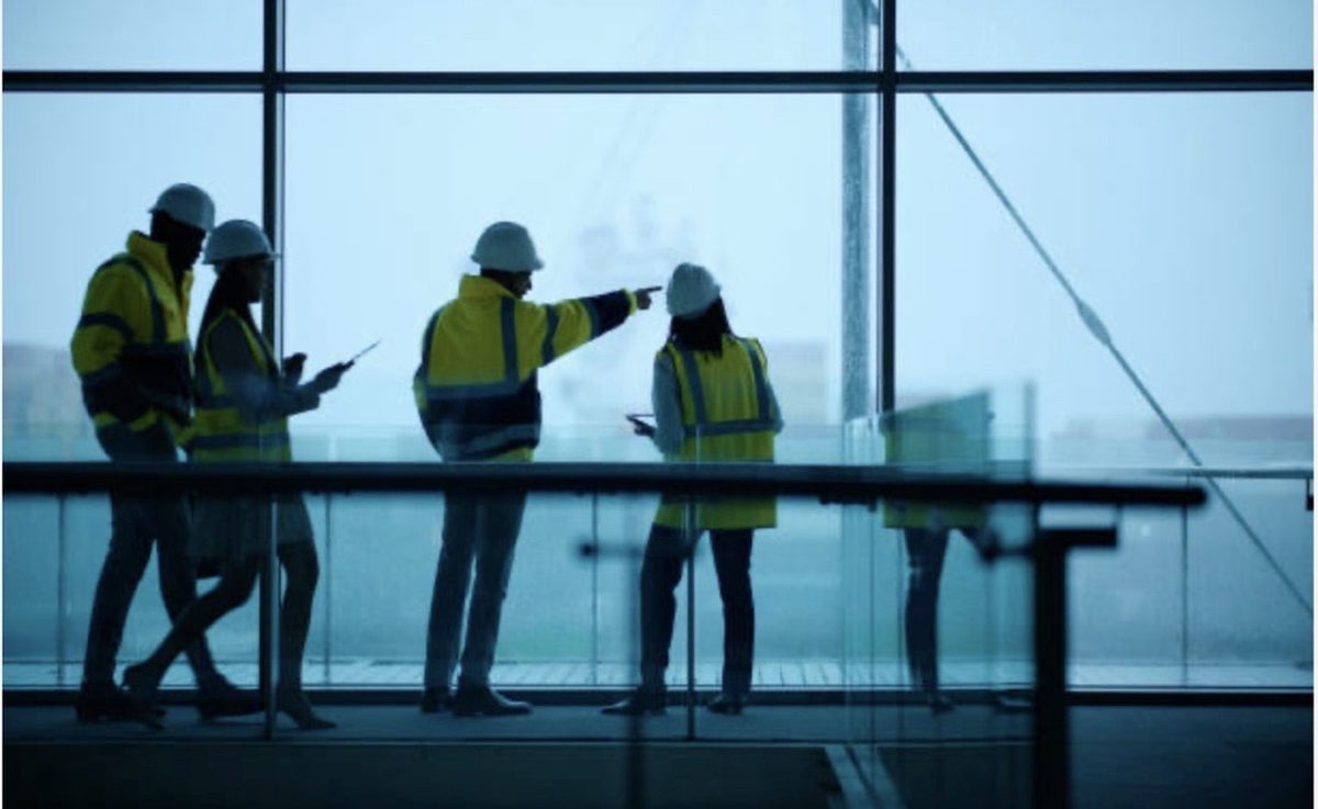 Consultants in hard hats reviewing site conditions on a construction platform